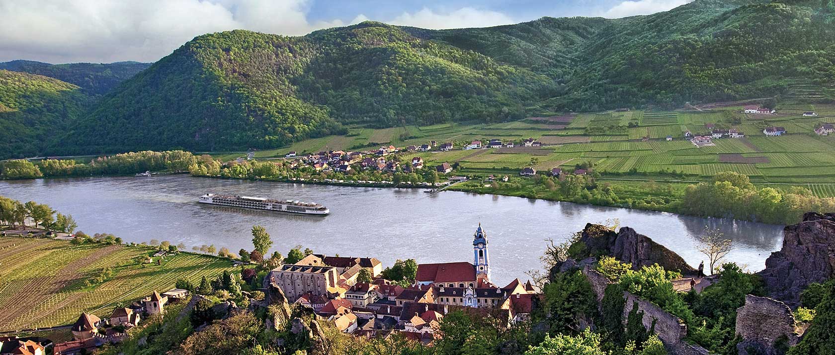 Aerial view of a Viking river ship sailing past Dürnstein, Austria along the Danube river