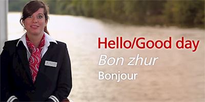 A woman in a black blazer with the words "Hello" in English and French overlayed in white text.