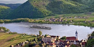A Viking river ship sailing past a European town